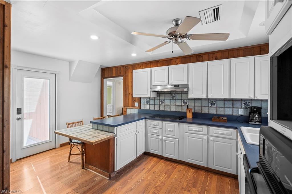 Spacious kitchen with ample counter space and cozy breakfast bar - Virtually Edited Image