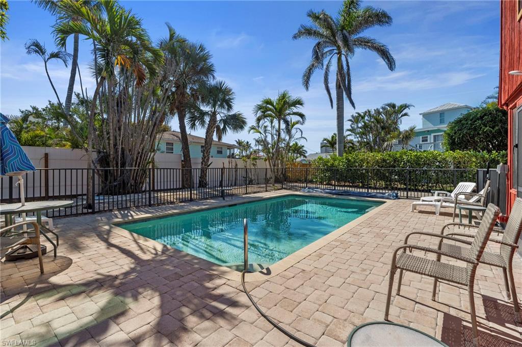 View of swimming pool with fence and a patio area - Virtually Edited Exterior Image