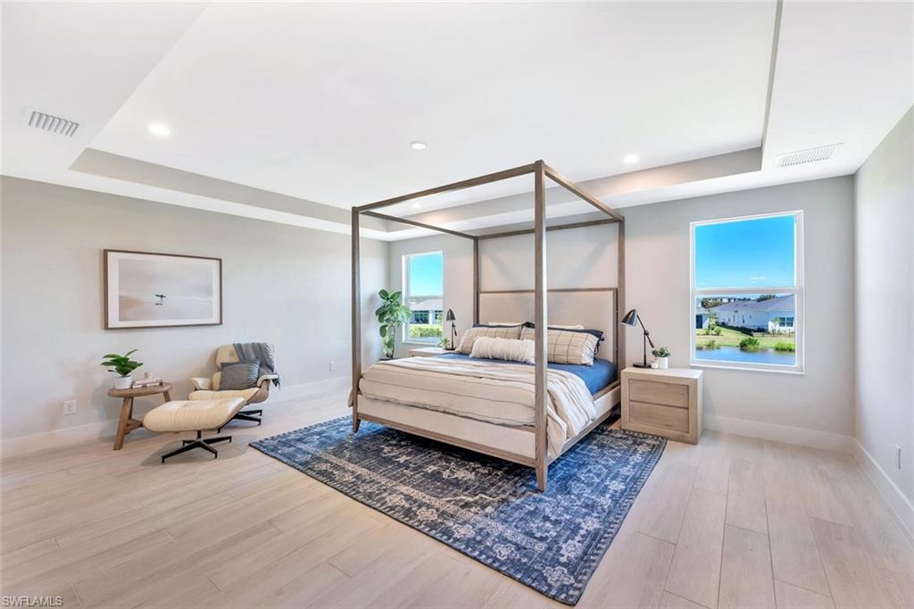 Sophisticated primary suite with tray ceiling, designer lighting, and irresistible luxury vibes