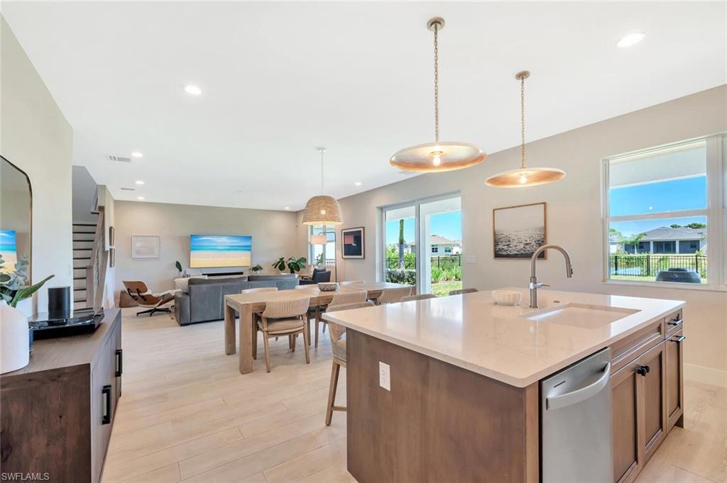 This open-concept living and dining area blends modern design with relaxed elegance. Warm wood tones, soft neutral walls, and natural light create a welcoming flow between the dining table, lounge space, and kitchen beyond. Clean lines and layered textures make it perfect for both casual gatherings and stylish entertaining—a space that feels effortlessly connected and inviting.