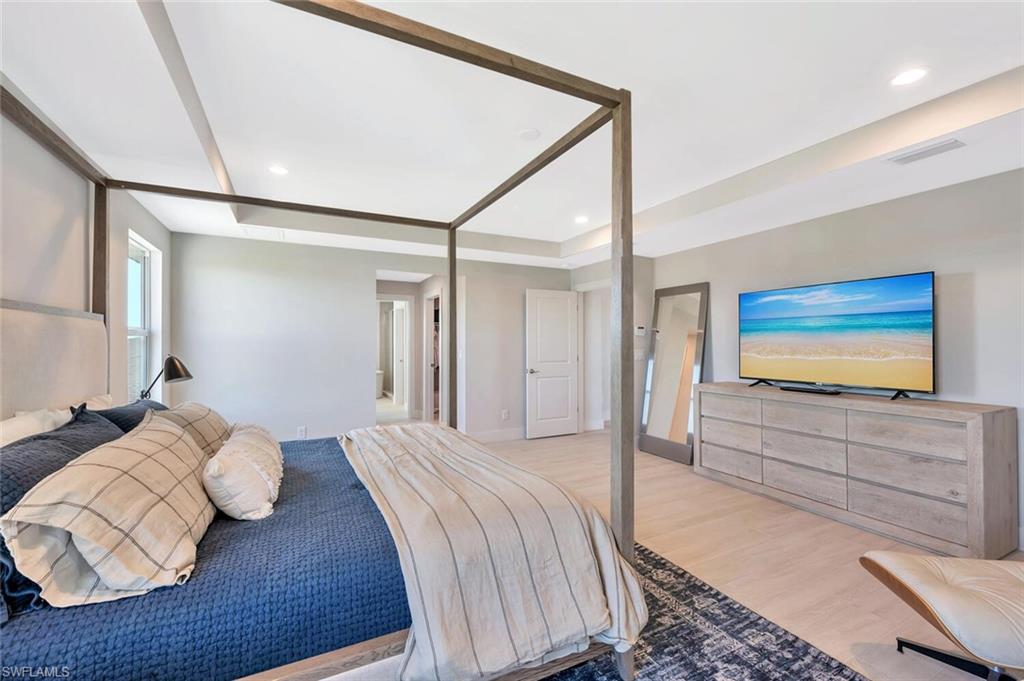 Sophisticated primary suite with tray ceiling, designer lighting, and irresistible luxury vibes