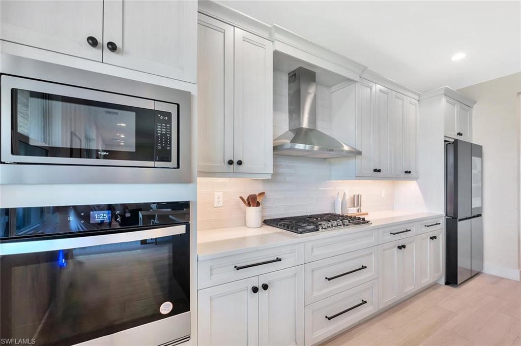 This kitchen pairs sleek functionality with modern farmhouse charm. Crisp white cabinetry, designer hardware, and stainless-steel appliances create a bright, polished look. A custom range hood, built-in oven and microwave, and quartz counters complete the space—clean, efficient, and made for both everyday living and effortless entertaining.