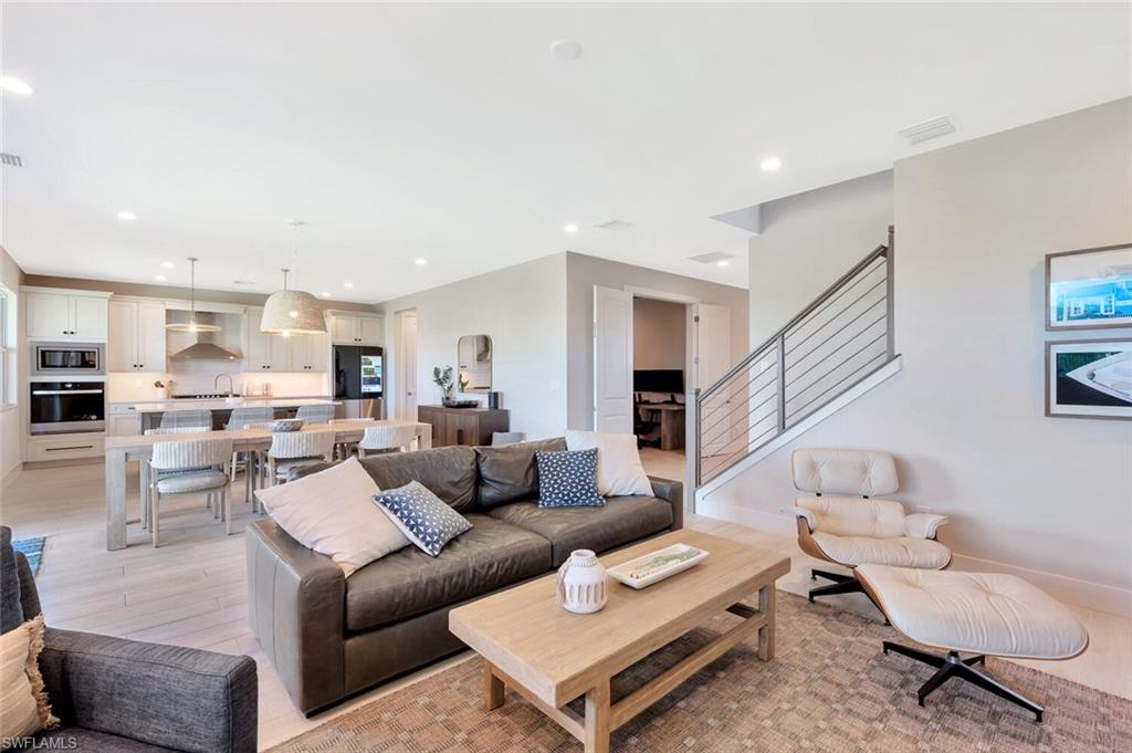 This open-concept living and dining area blends modern design with relaxed elegance. Warm wood tones, soft neutral walls, and natural light create a welcoming flow between the dining table, lounge space, and kitchen beyond. Clean lines and layered textures make it perfect for both casual gatherings and stylish entertaining—a space that feels effortlessly connected and inviting.