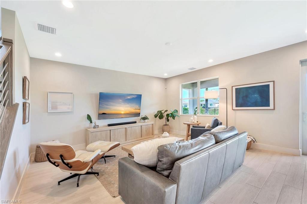 This open-concept living and dining area blends modern design with relaxed elegance. Warm wood tones, soft neutral walls, and natural light create a welcoming flow between the dining table, lounge space, and kitchen beyond. Clean lines and layered textures make it perfect for both casual gatherings and stylish entertaining—a space that feels effortlessly connected and inviting.
