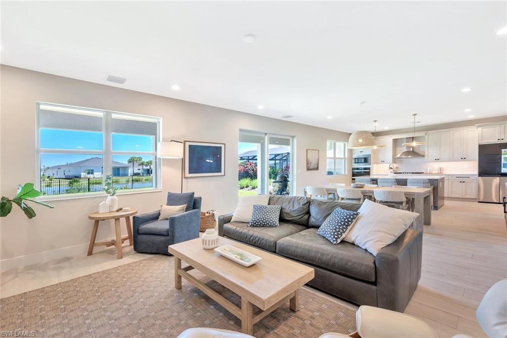 This open-concept living and dining area blends modern design with relaxed elegance. Warm wood tones, soft neutral walls, and natural light create a welcoming flow between the dining table, lounge space, and kitchen beyond. Clean lines and layered textures make it perfect for both casual gatherings and stylish entertaining—a space that feels effortlessly connected and inviting.