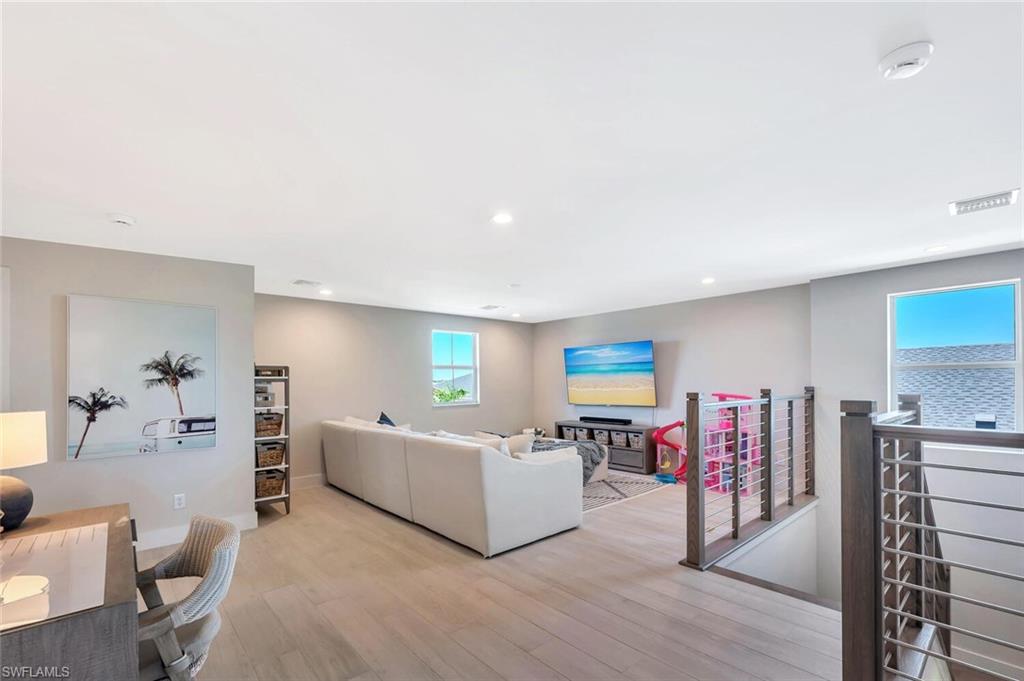 The second-floor family room is an airy, open-concept loft that feels both stylish and relaxed. Natural light fills the space, highlighting clean lines, neutral tones, and a soft modern palette that ties seamlessly with the rest of the home.A sleek metal railing gives the area an architectural edge, overlooking the dramatic staircase below. It’s an ideal gathering spot—large enough for movie nights, game time, or quiet reading—with a flexible layout that invites creativity. Subtle recessed lighting, con