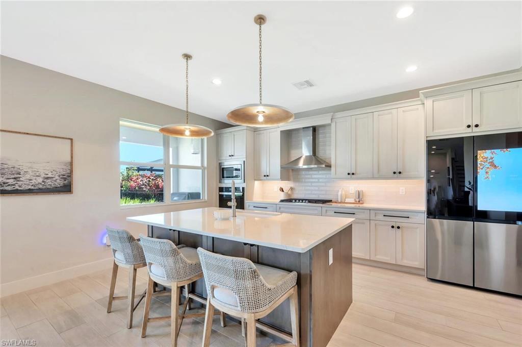 This kitchen pairs sleek functionality with modern farmhouse charm. Crisp white cabinetry, designer hardware, and stainless-steel appliances create a bright, polished look. A custom range hood, built-in oven and microwave, and quartz counters complete the space—clean, efficient, and made for both everyday living and effortless entertaining.