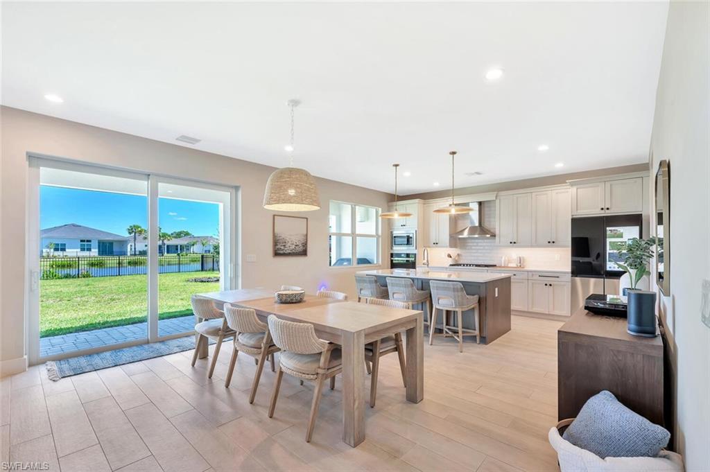 This open-concept living and dining area blends modern design with relaxed elegance. Warm wood tones, soft neutral walls, and natural light create a welcoming flow between the dining table, lounge space, and kitchen beyond. Clean lines and layered textures make it perfect for both casual gatherings and stylish entertaining—a space that feels effortlessly connected and inviting.