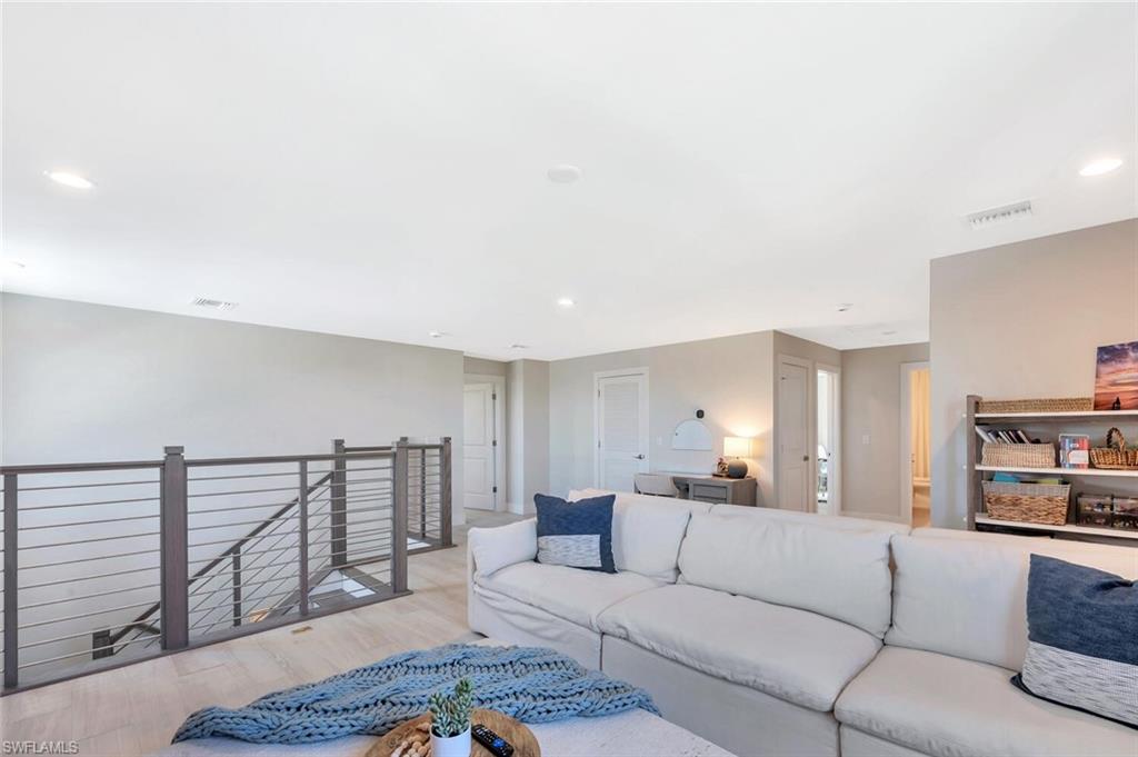 The second-floor family room is an airy, open-concept loft that feels both stylish and relaxed. Natural light fills the space, highlighting clean lines, neutral tones, and a soft modern palette that ties seamlessly with the rest of the home.A sleek metal railing gives the area an architectural edge, overlooking the dramatic staircase below. It’s an ideal gathering spot—large enough for movie nights, game time, or quiet reading—with a flexible layout that invites creativity. Subtle recessed lighting, con
