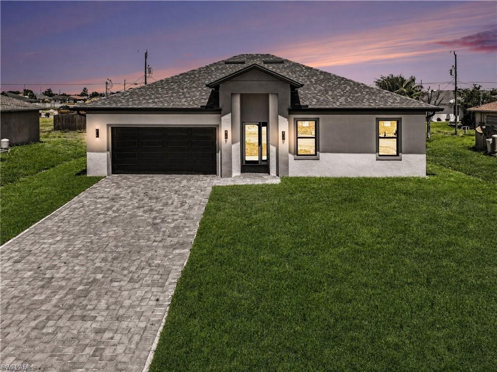 Contemporary-style residence featuring a dark asphalt shingle roof and a two-tone stucco exterior.  The color of the grass has been virtually modified.