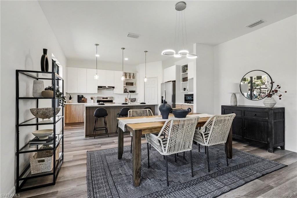 Open-concept living space featuring wood-finish flooring and a contemporary kitchen