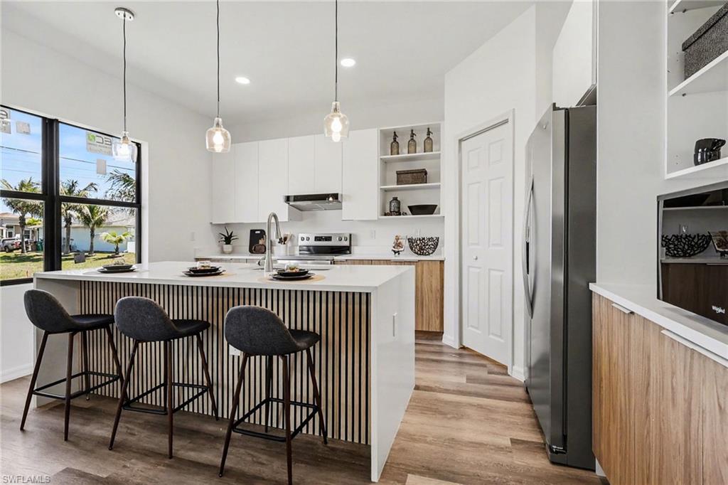 Modern kitchen featuring an expansive island with a slatted wood-finish accent panel