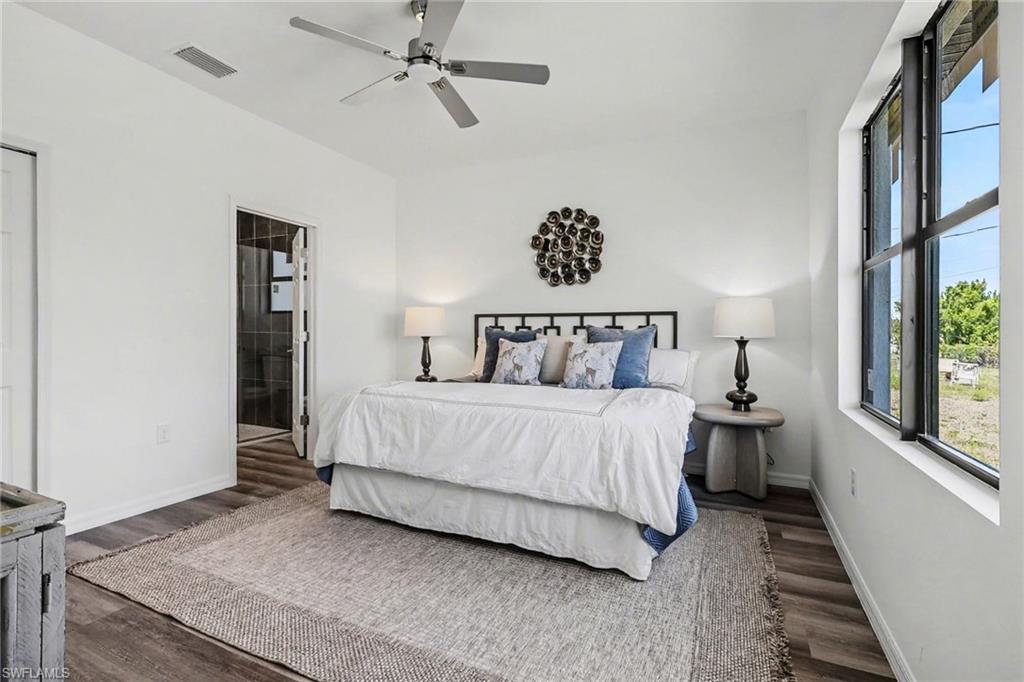Spacious interior room featuring wood-finish flooring, a ceiling fan, and ample natural light from a large window