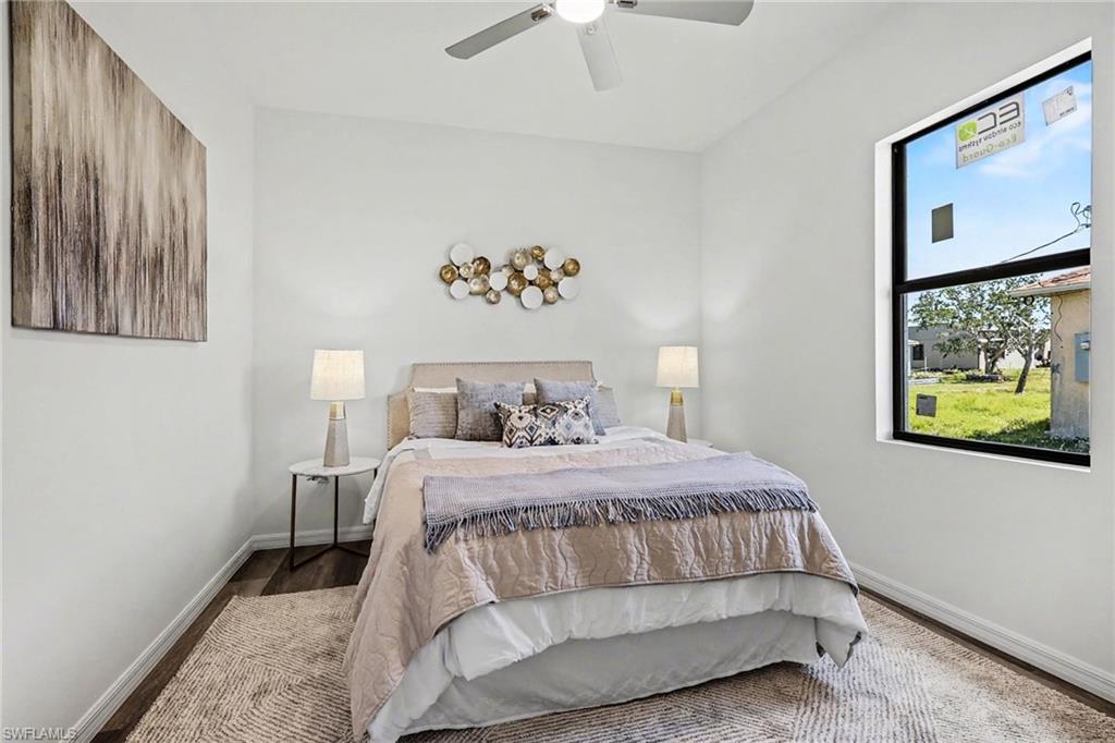 Bright room featuring a ceiling fan, a large window, and wood-finish flooring