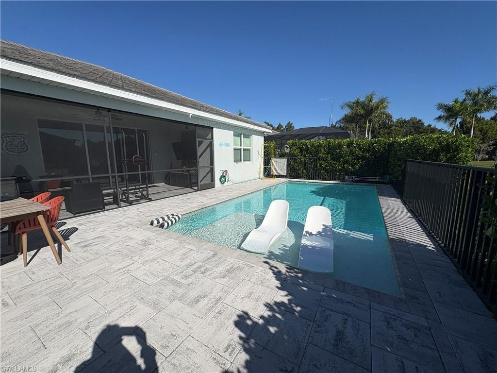 Rectangular pool with integrated sun shelf surrounded by a textured paver deck
