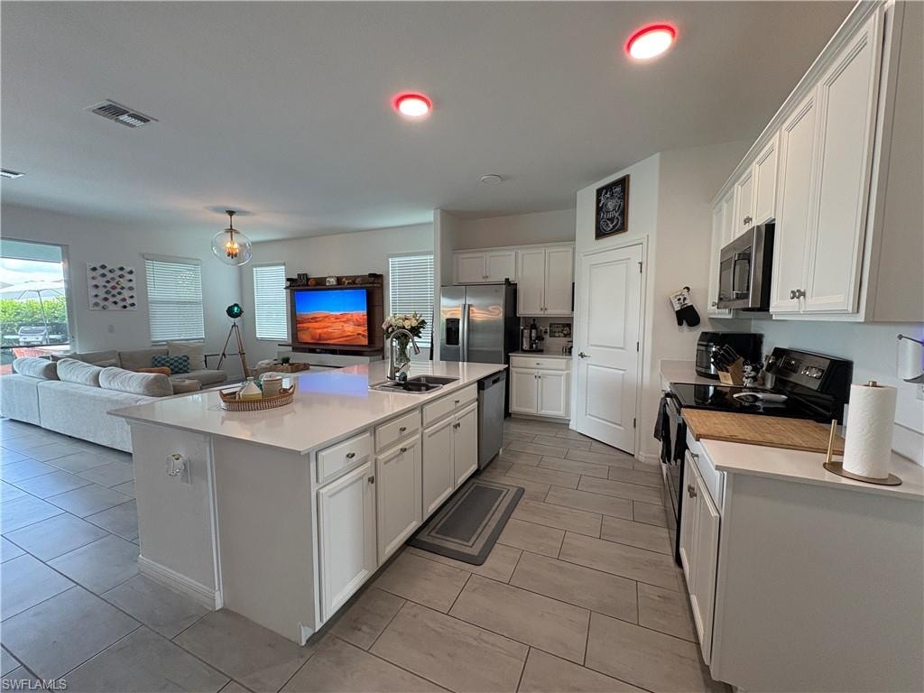 Central kitchen island featuring a substantial countertop and an undermount sink