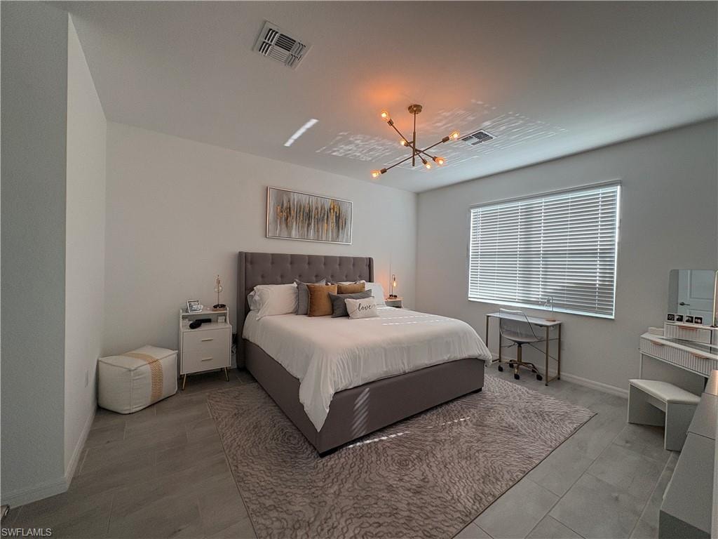 Spacious room featuring light-toned walls, tile flooring, and a large window with blinds