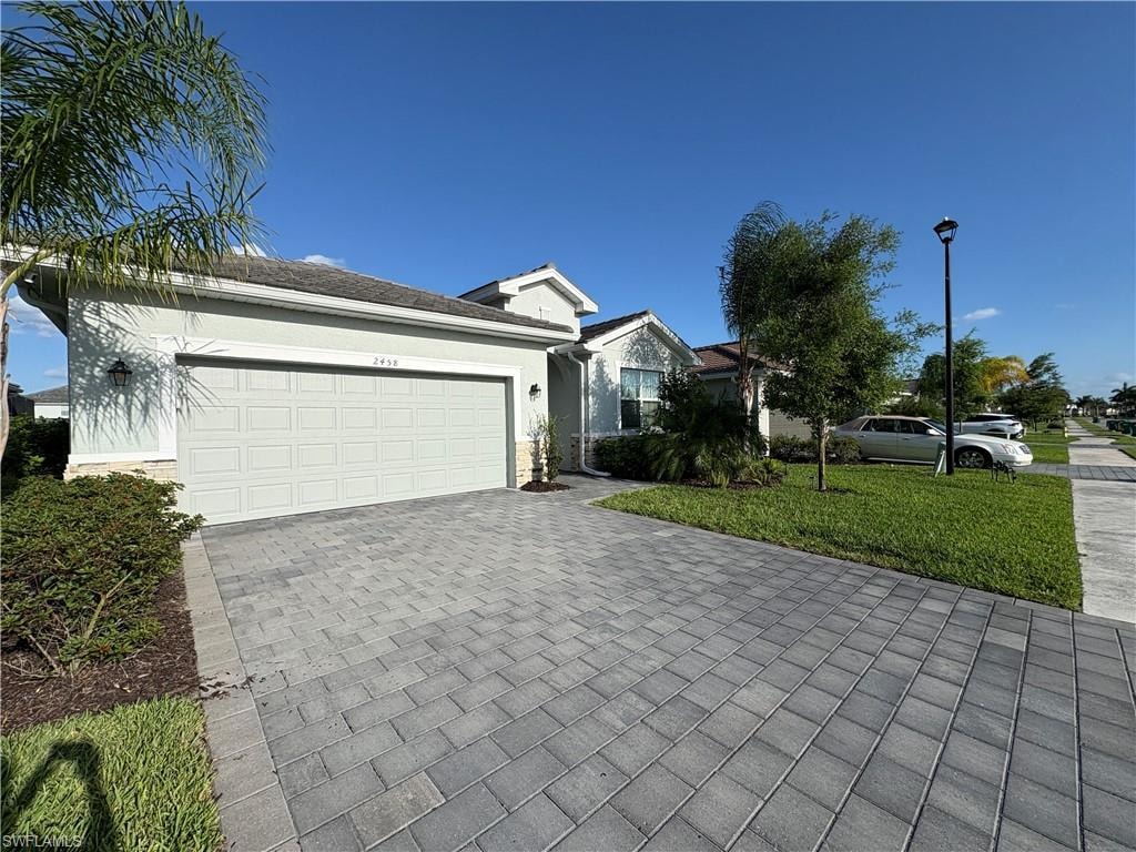 Paver driveway leading to a two-car garage