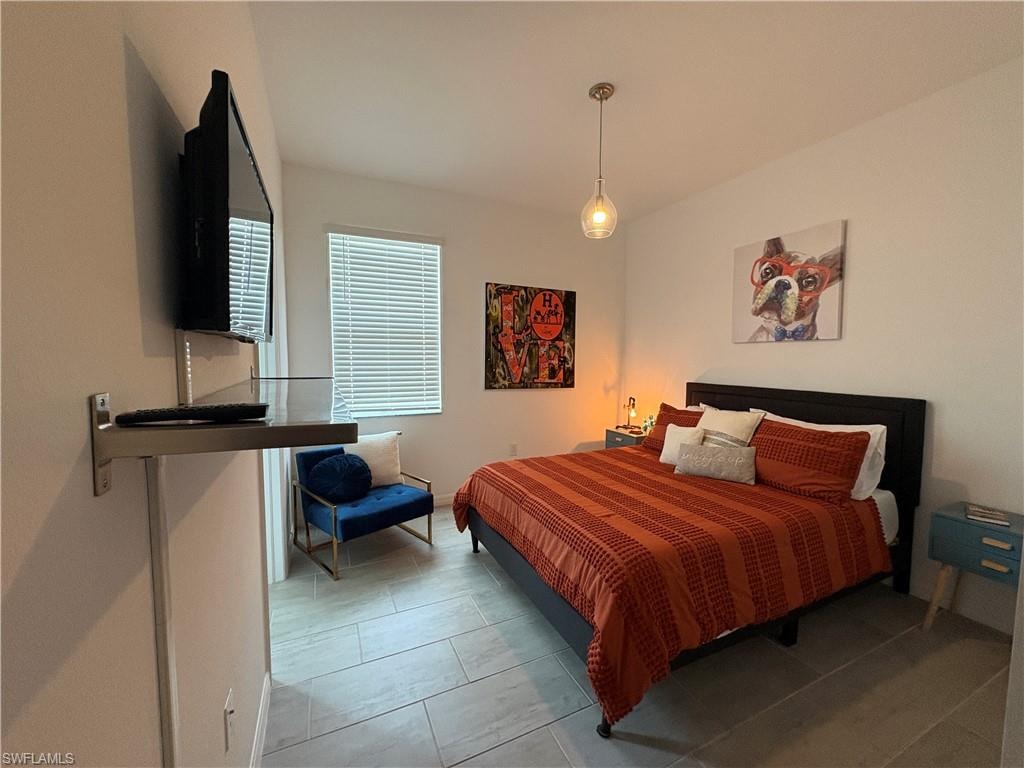 Spacious room with light-colored tile flooring and a large window featuring horizontal blinds