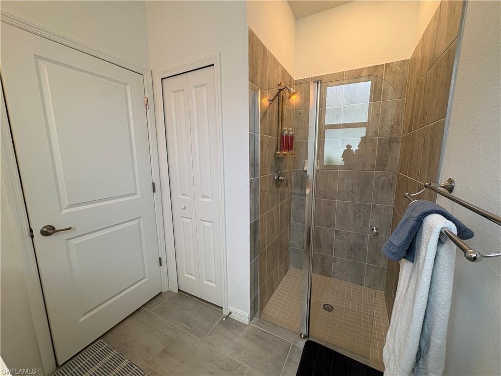 Walk-in shower with full-height tile surround, clear glass enclosure, and integrated window