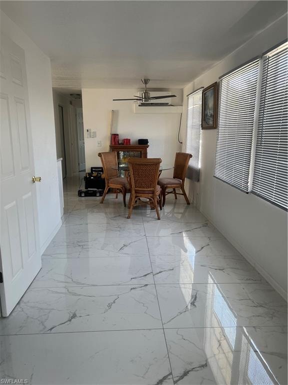 Dining area featuring marble finish floor, baseboards, and ceiling fan