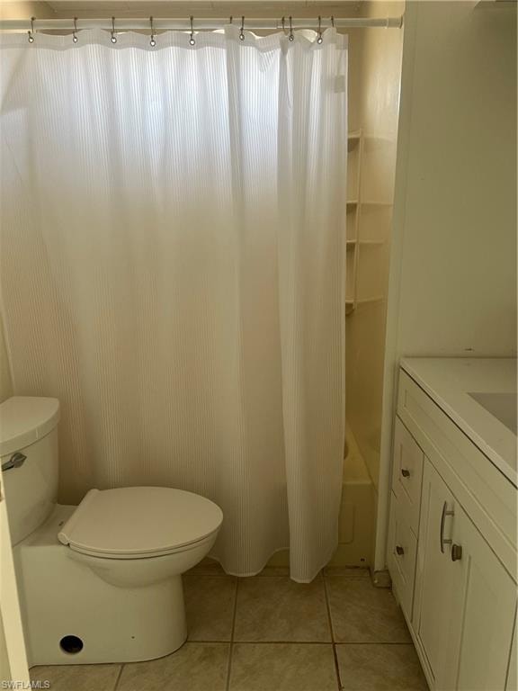 Bathroom with shower / tub combo with curtain, vanity, tile patterned flooring, and toilet