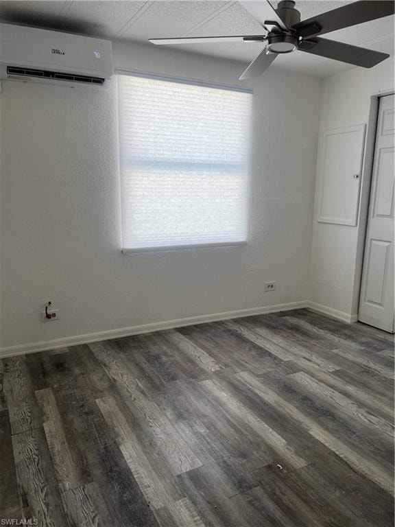 Empty room featuring baseboards, a ceiling fan, wood finished floors, and a wall mounted AC