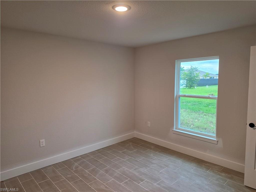 Room featuring neutral-toned walls, wood-finish tile flooring, recessed ceiling lighting, a single window, and white baseboards