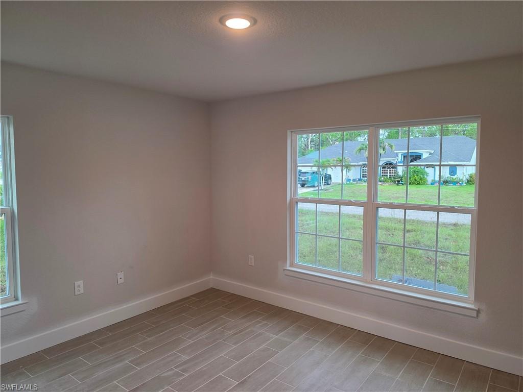 Room featuring light neutral wall tones and wood-finish tile flooring