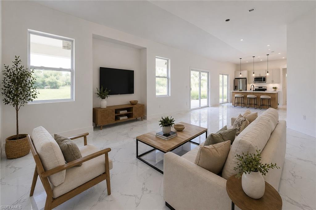 Open-concept living space featuring high ceilings and large format tile flooring