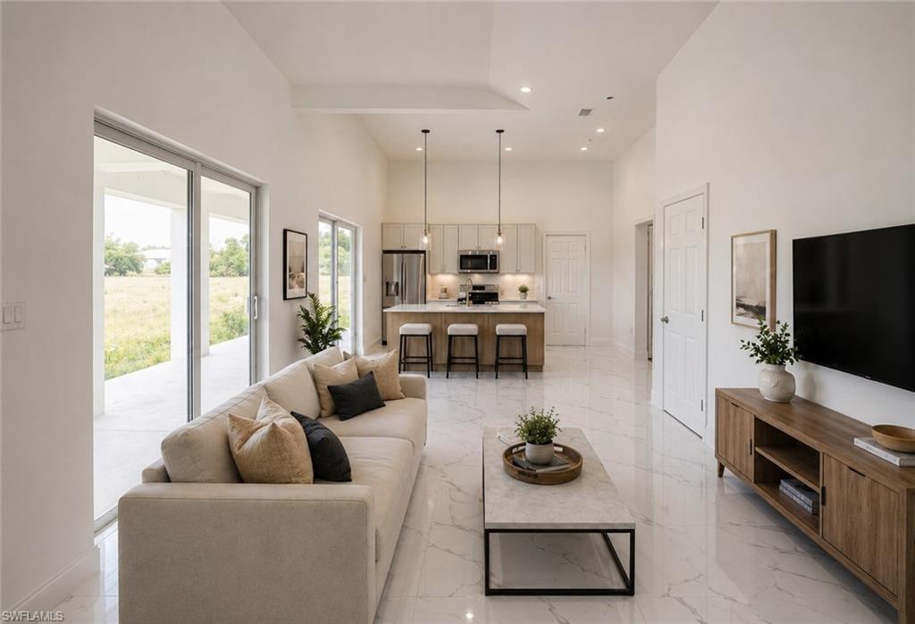 Open-concept living area featuring high vaulted ceilings and tile flooring. Image digitally enhanced and virtually altered; actual property condition may differ.