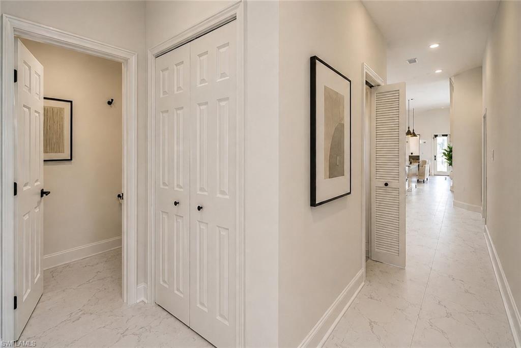 Hallway featuring white panel doors, white louvered doors. Image digitally enhanced and virtually altered; actual property condition may differ.