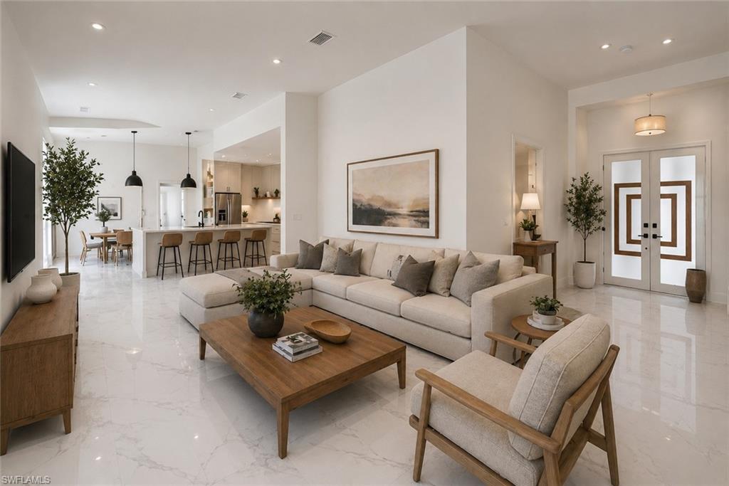 Open-concept living area featuring high ceilings, recessed lighting, and large format tile flooring. Image digitally enhanced and virtually altered; actual property condition may differ..