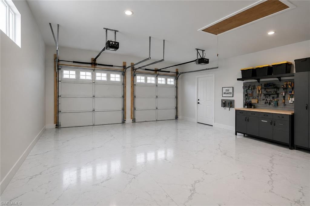 Two-car garage featuring automated overhead doors with window accents. Image digitally enhanced and virtually altered; actual property condition may differ.