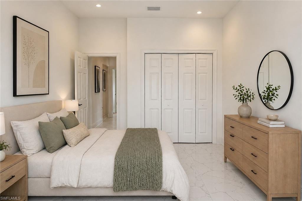 Spacious room featuring white walls, recessed lighting, and large bi-fold closet doors. Image digitally enhanced and virtually altered; actual property condition may differ.