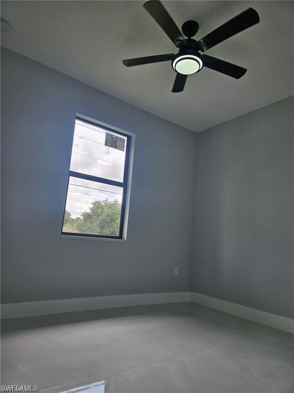 Empty room with baseboards and ceiling fan