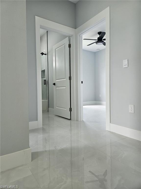 Hallway with baseboards and light marble finish flooring