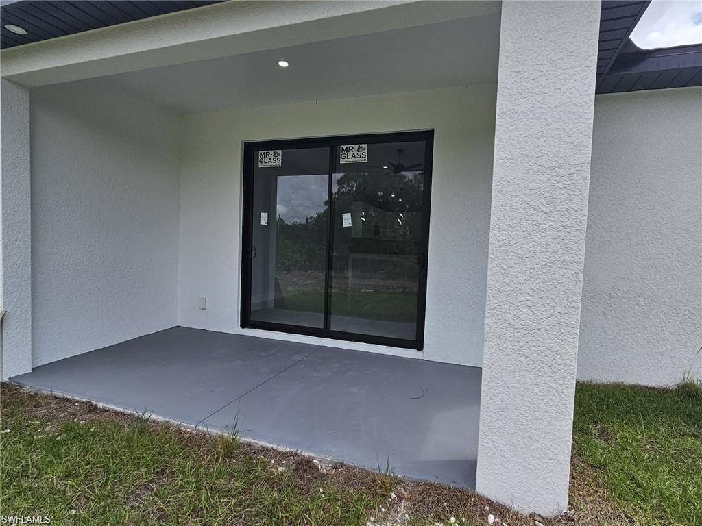 Doorway to property featuring stucco siding