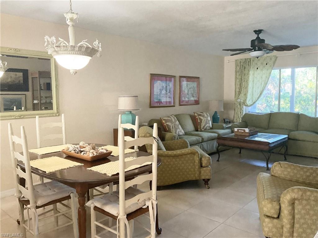 Dining and living area with light tile, ceiling fan & TV