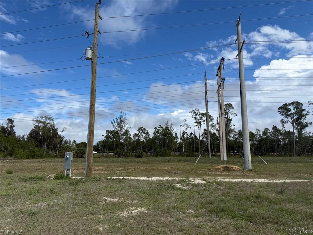 Expansive raw land parcel featuring a utility pole with an attached transformer, overhead power lines, and a dedicated utility box