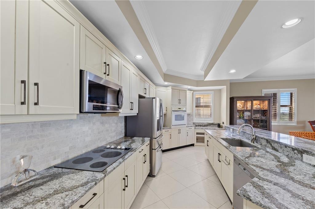 The kitchen features light-colored cabinetry with dark hardware, granite countertops, and stainless steel appliances
