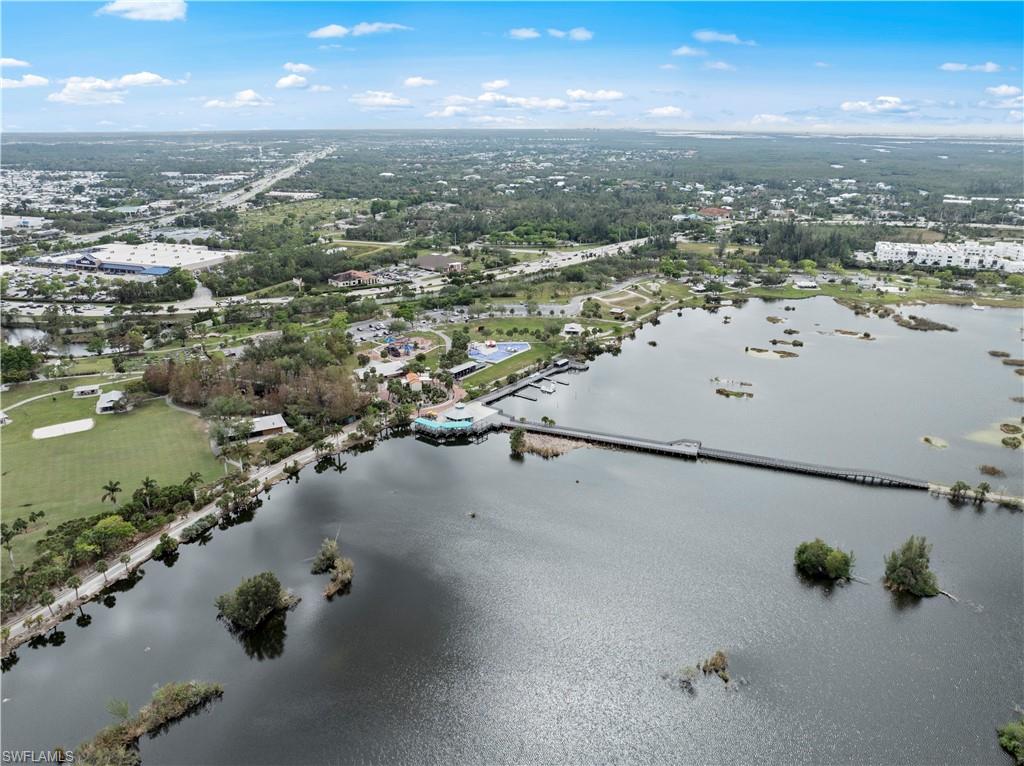 Aerial view showcasing the community with a large body of water, extensive green spaces, and surrounding development