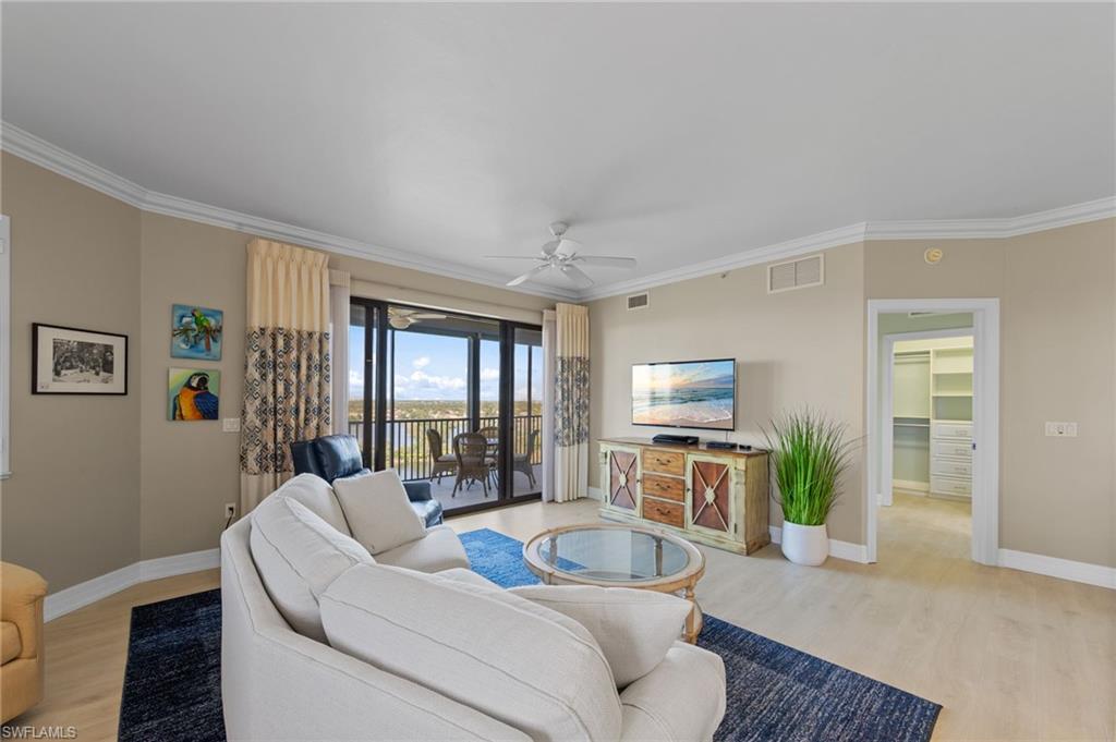 Living area featuring light-toned flooring, crown molding, a ceiling fan, and a view of the outdoor patio