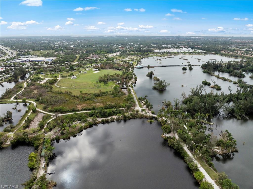 Expansive aerial view showcasing a large body of water, lush green areas, and surrounding urban development