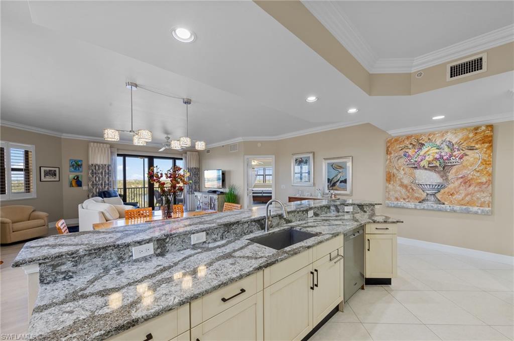 The kitchen features an expansive granite countertop with an integrated sink and light-colored cabinetry