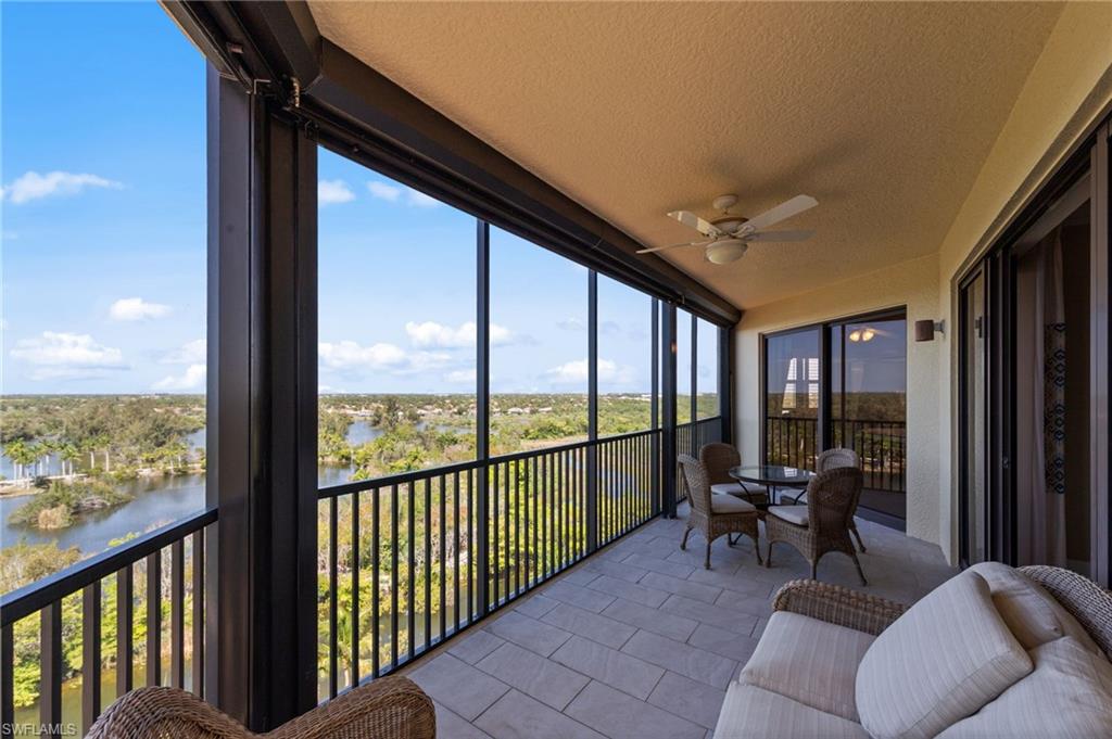 The property features an expansive screened balcony with tiled flooring and ceiling fan, offering panoramic views of the surrounding landscape and water
