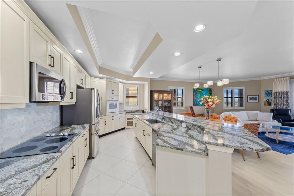 Well-appointed kitchen featuring light-colored cabinetry, stainless steel appliances, and granite countertops