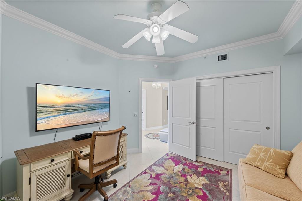 This room features light blue walls, white crown molding, and a ceiling fan with integrated lighting
