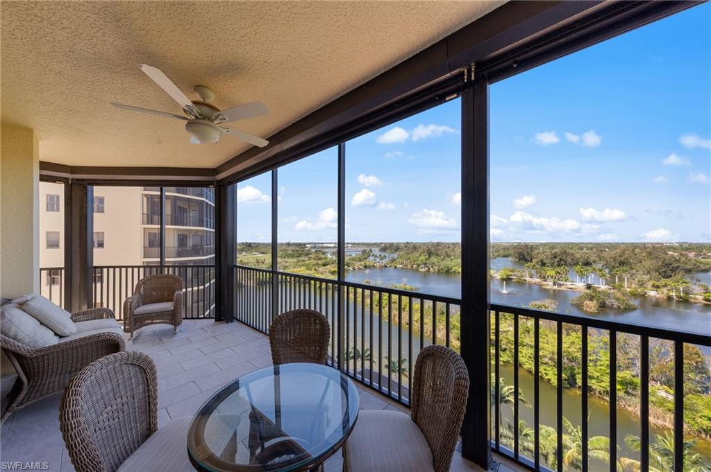 Spacious balcony featuring tile flooring and a ceiling fan, offering expansive views of the lake and surrounding greenery
