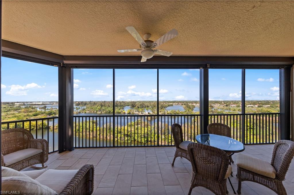 The property features an expansive screened-in balcony with tiled flooring and a ceiling fan, offering panoramic views of the surrounding water and landscapes